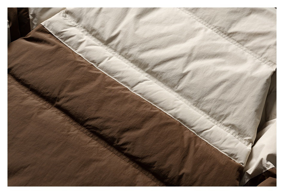 Close-up of brown and cream garment panels meeting along a diagonal stitched seam.