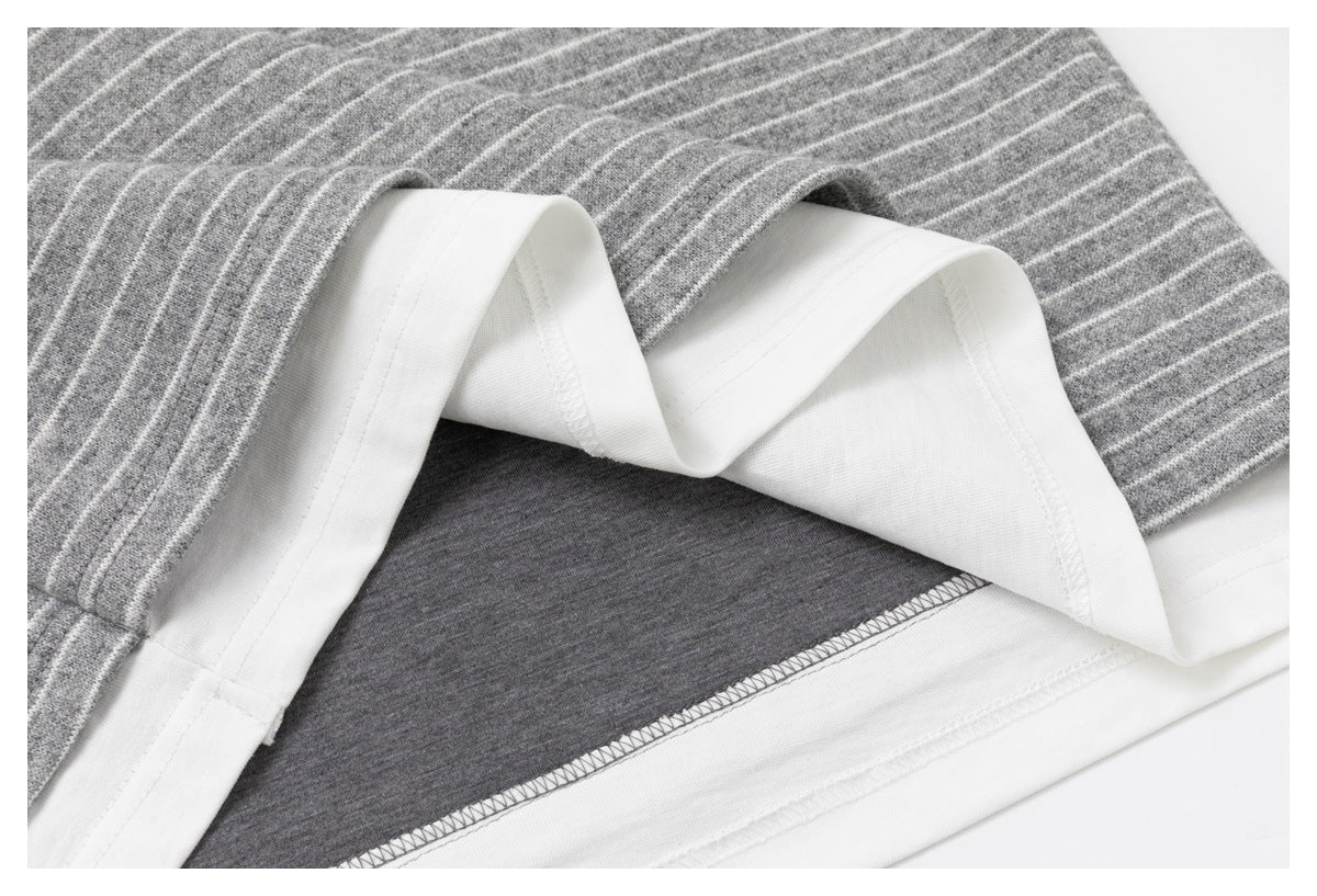 Close-up of the shirt's folded white hem facing and overlock seam beneath gray-and-white stripes.