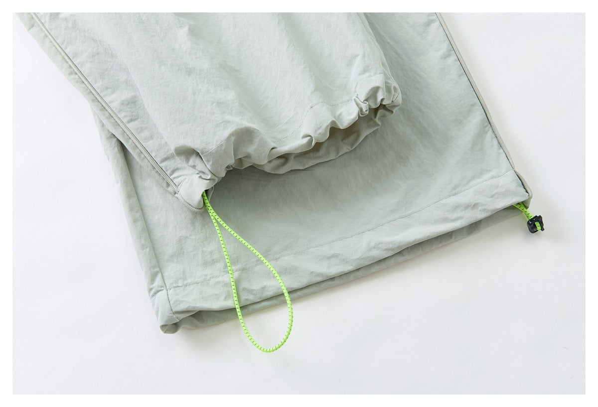 Close-up of the pants cuff with a lime drawcord and cord lock for adjustment.