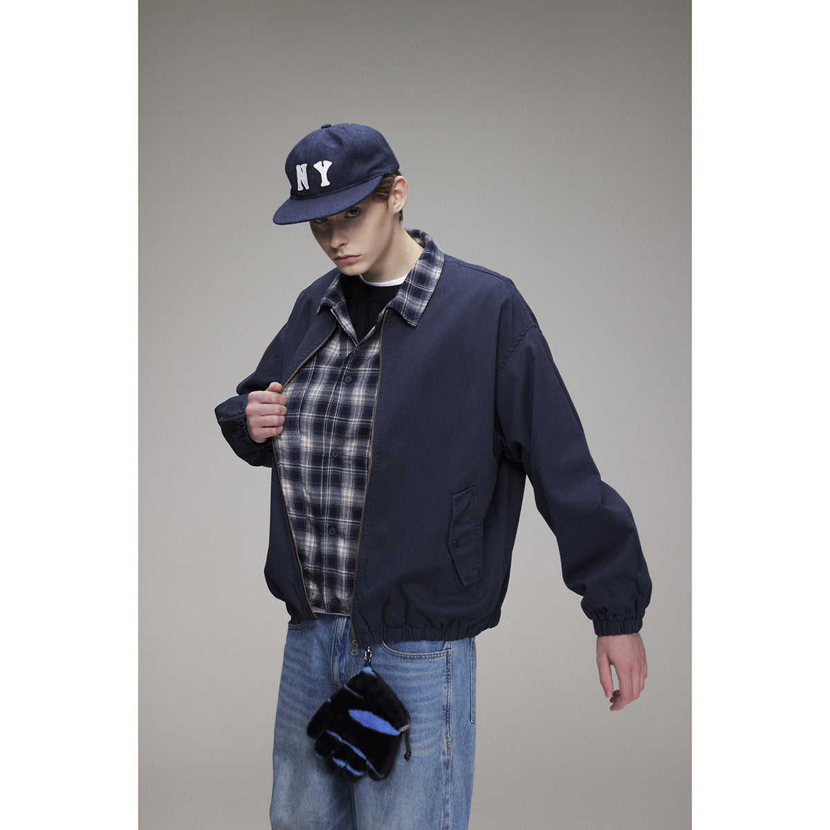 Model displays the navy jacket's plaid shirt layers, zip front, elastic cuffs, and side pocket.
