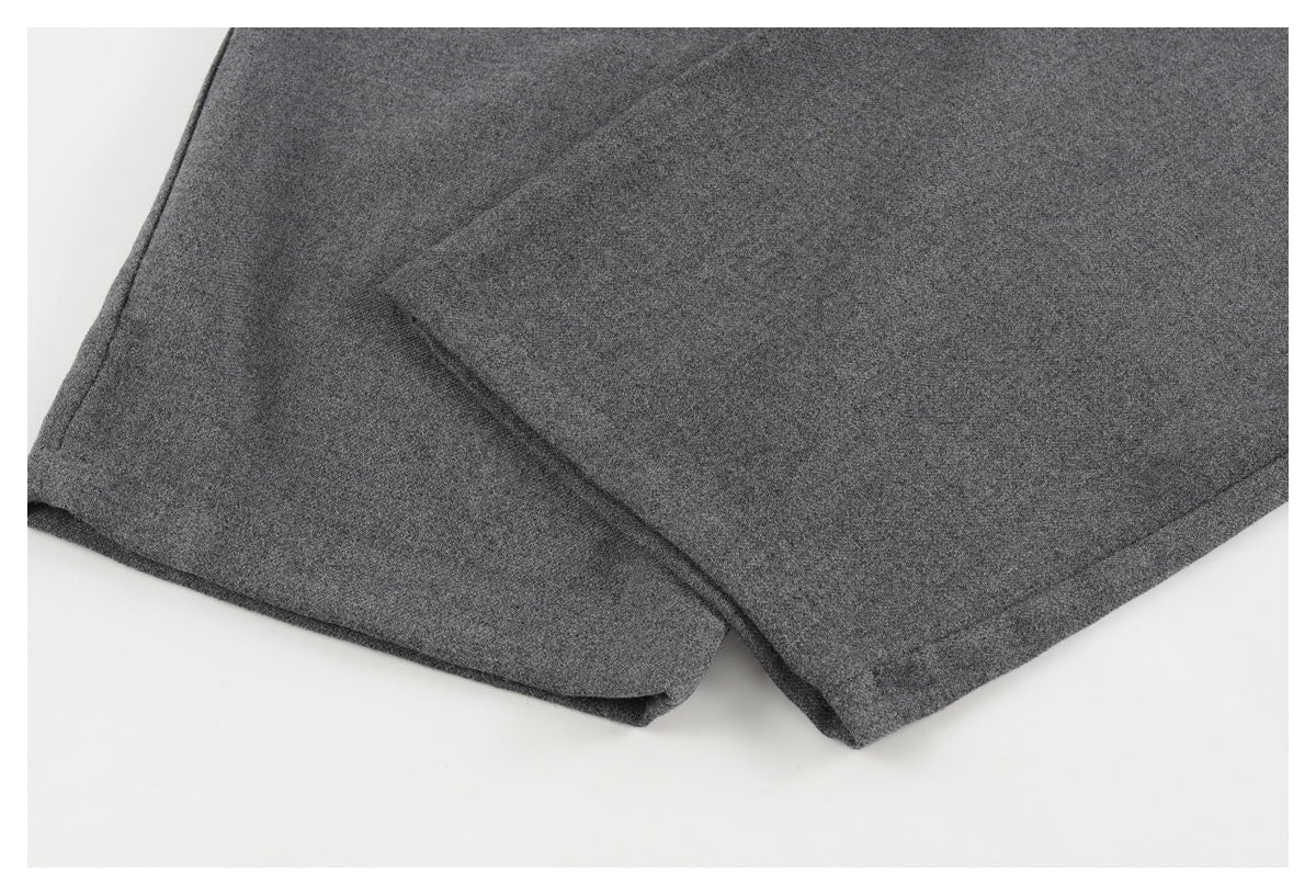 Close-up of a charcoal gray pant leg showing its folded, stitched hem.