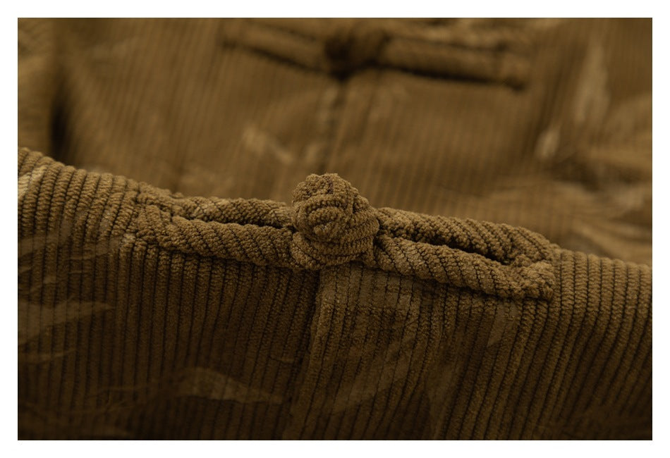 Close-up of a brown corduroy shirt with a fabric-covered button and ribbed, subtly patterned fabric.