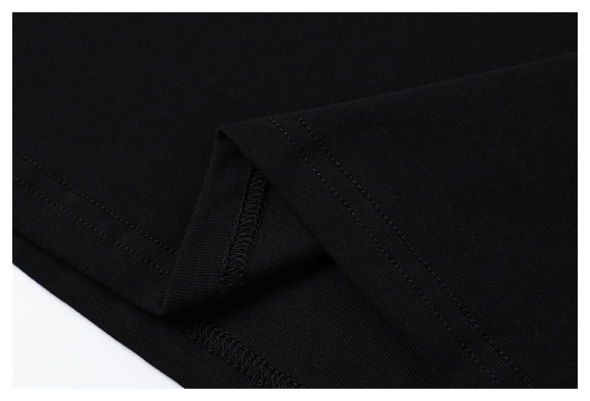 Close-up of the black T-shirt's folded hem and interior overlock stitching.