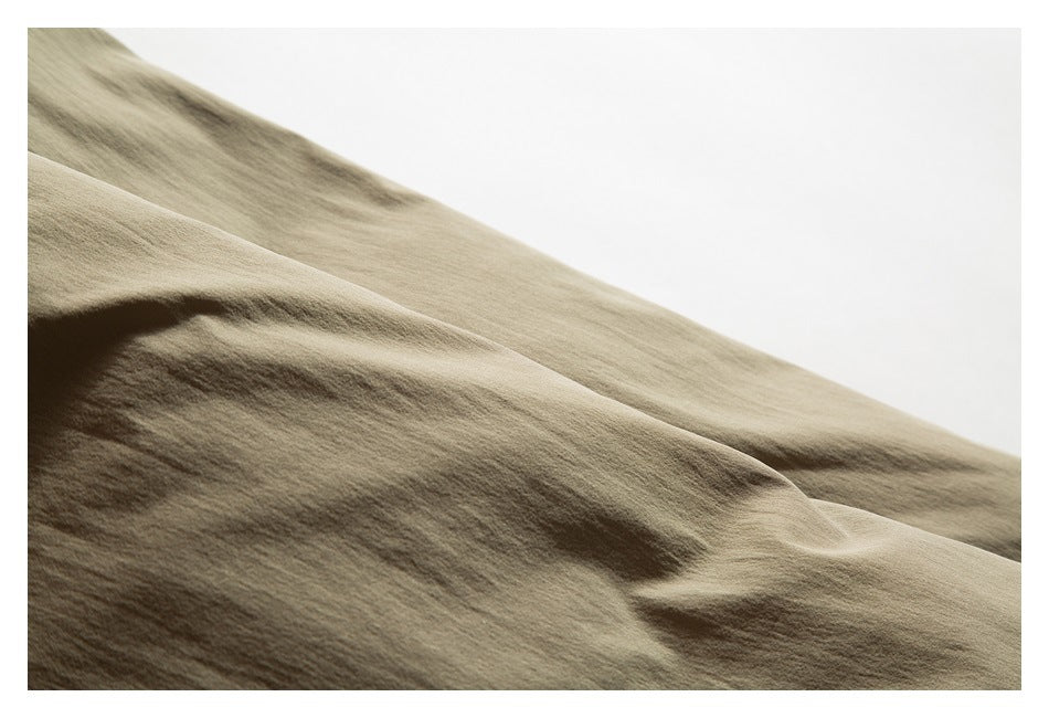 Close-up of smooth, softly folded olive-khaki garment fabric.