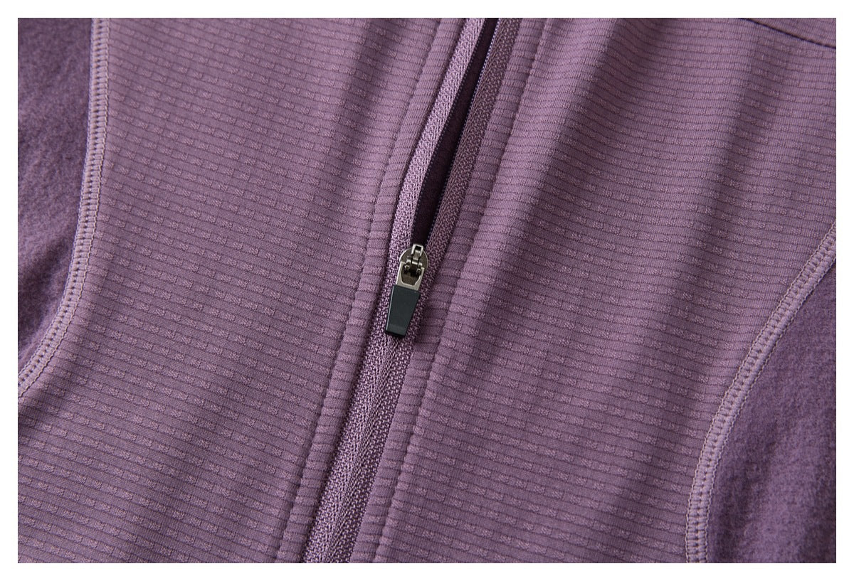 Close-up of the purple jacket's central zipper, ribbed fabric, and adjoining panel seams.