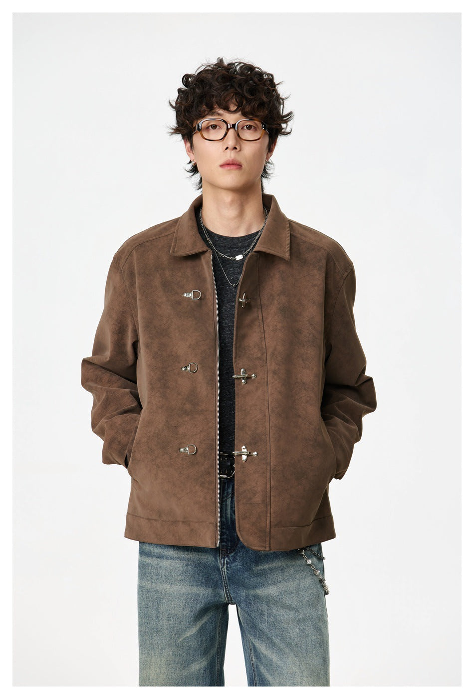 Front view of a model wearing a brown collared jacket with metal toggle closures and blue jeans.