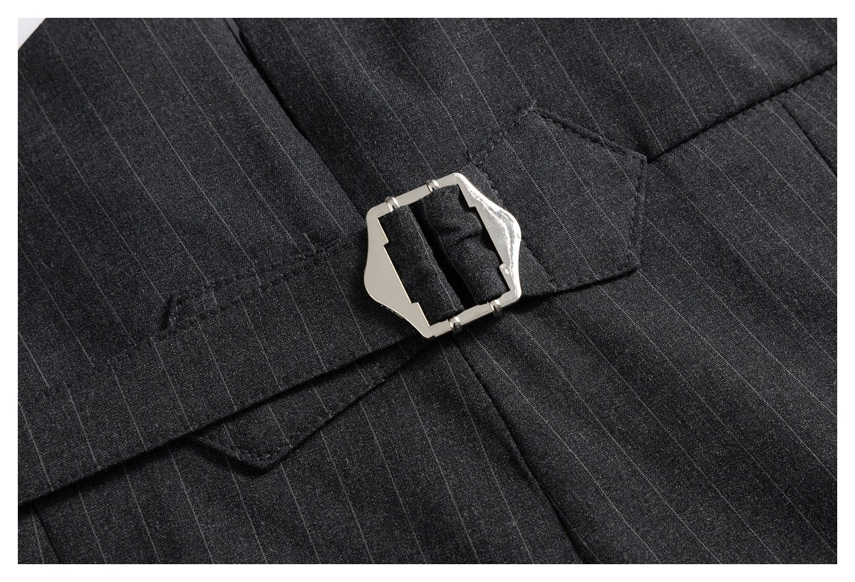 Close-up of the silver buckle on a matching waist strap over charcoal pinstripe trousers.