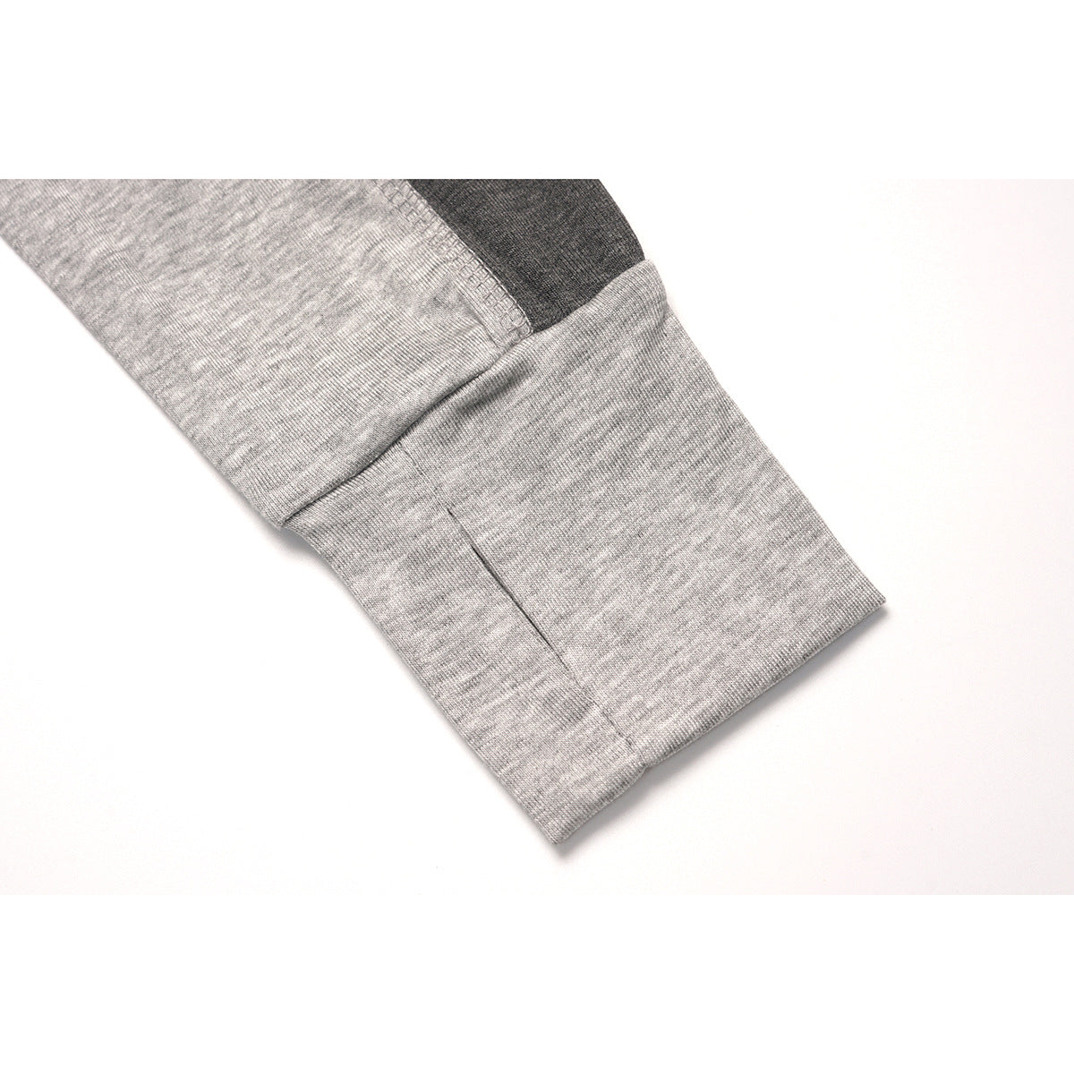 Close-up of a heather-gray sleeve ending in a wide cuff, with a dark contrast panel above it.