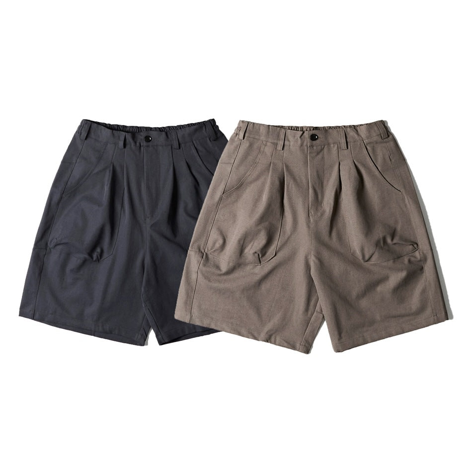 Front view of pleated shorts with curved pockets in charcoal and taupe.
