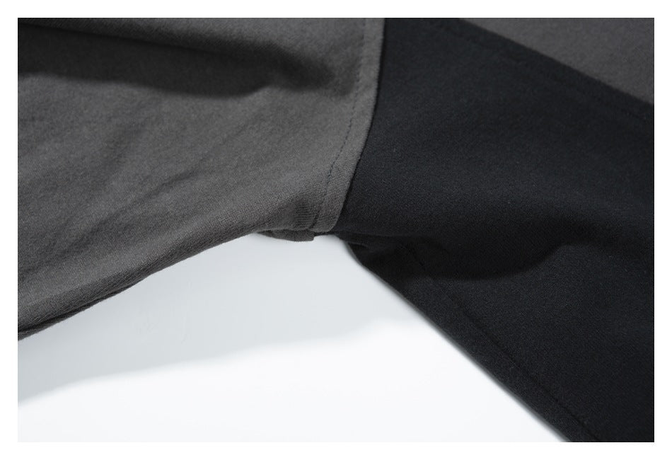 Close-up of a seam joining a charcoal-gray panel to a black garment panel.