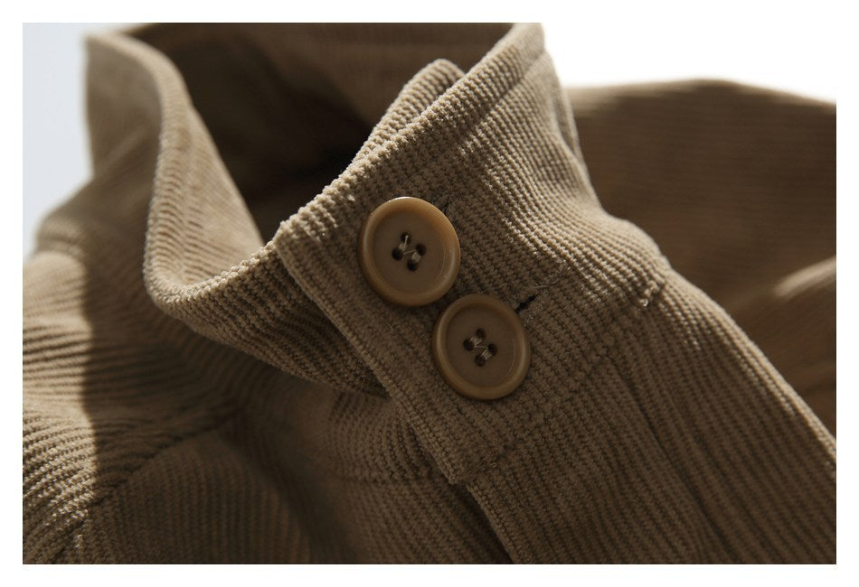 Close-up of two brown buttons on a folded edge of tan corduroy fabric.