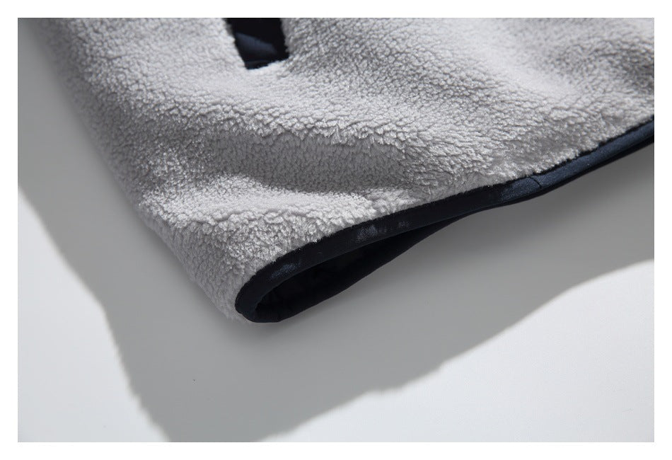 Close-up of the light gray fleece garment's lower edge with dark trim.