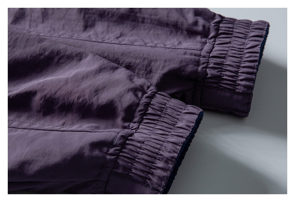 Close-up of two gathered elastic cuffs on a dark purple garment.