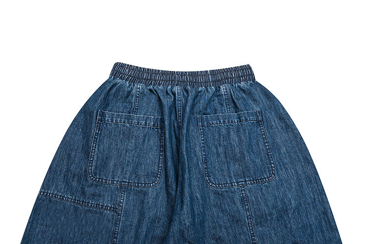 Cropped back view of blue denim bottoms with an elastic waistband and two patch pockets.