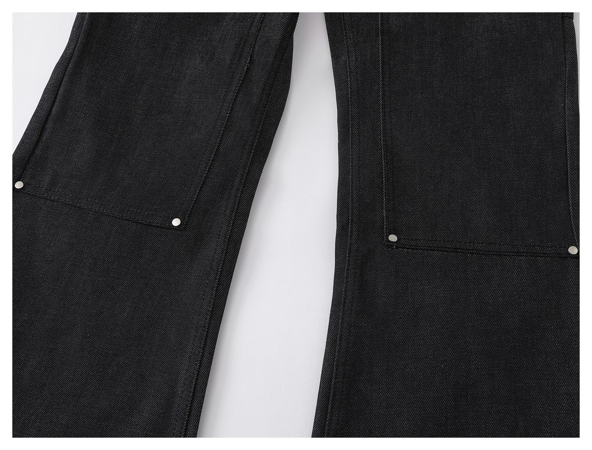 Close-up of black pant legs with large rectangular stitched pockets and silver rivets.