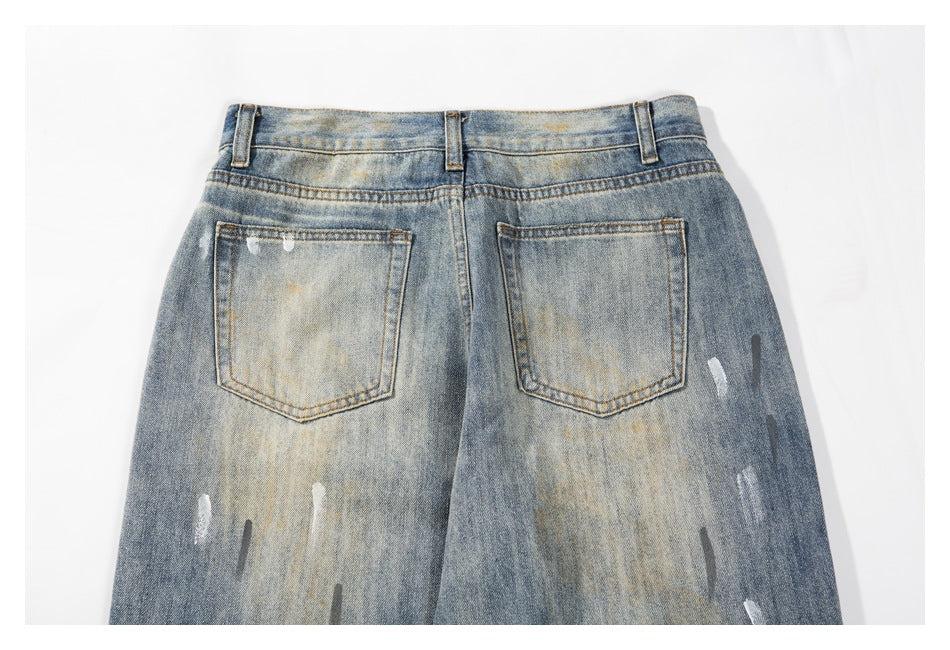 Back view of faded blue jeans laid flat, showing two patch pockets, belt loops, and distressed marks.
