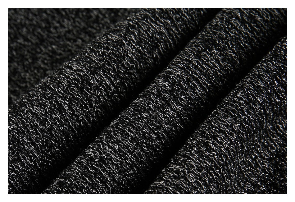 Macro view of the dark charcoal knit fabric draped in folds, showing its textured stitches.