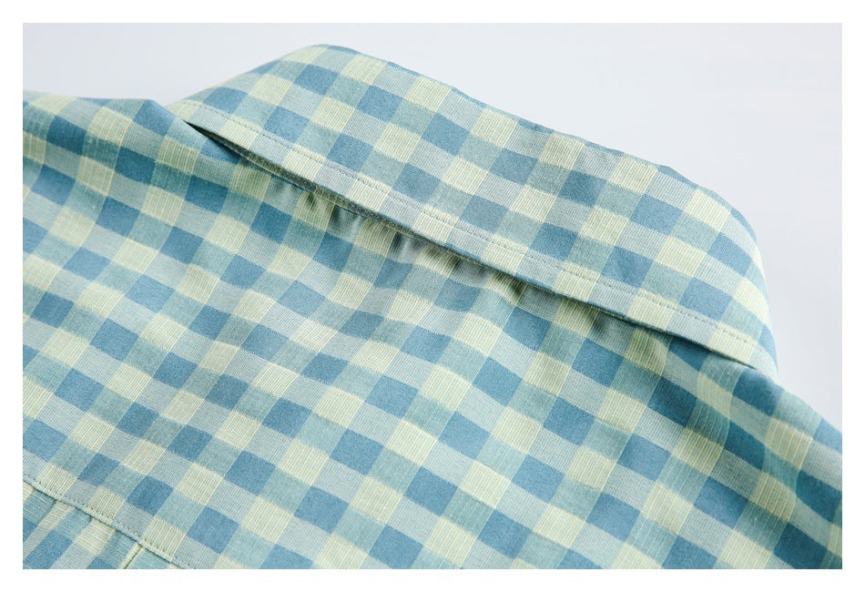 Close-up of a blue and pale yellow check shirt showing its collar and stitched seams.