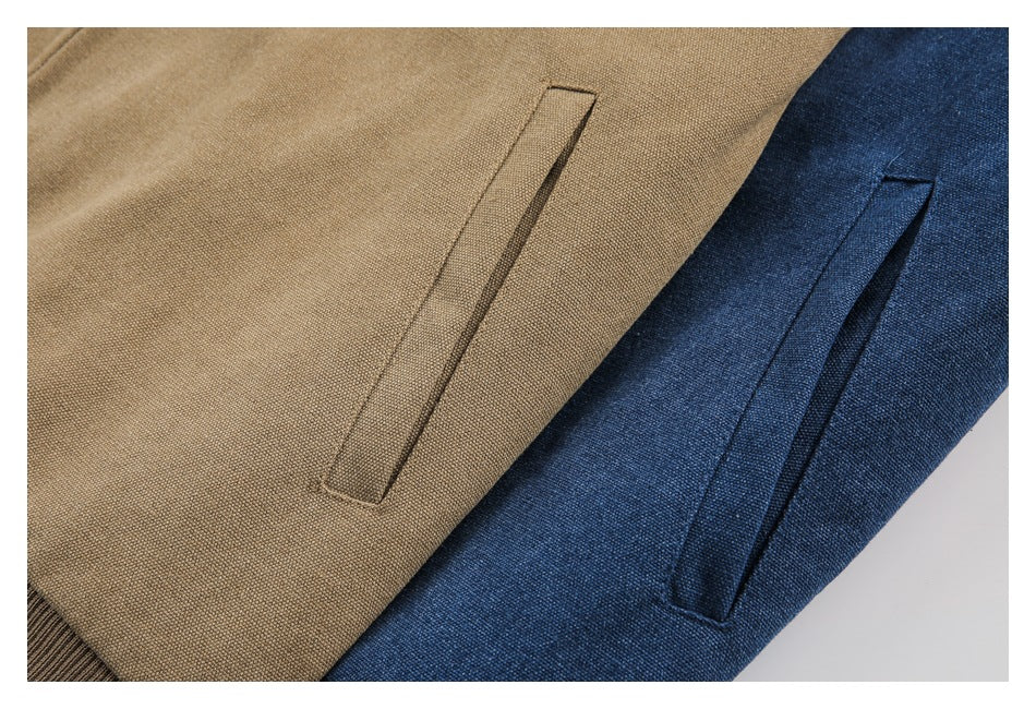 Close-up of slanted welt pockets on tan and dark blue textured jacket panels.