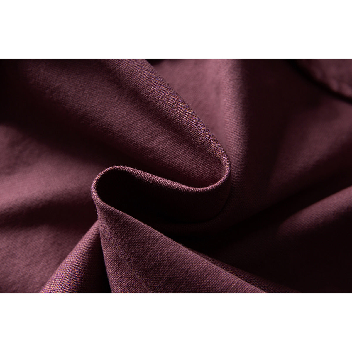 Macro view of burgundy jacket fabric folded to show its surface and texture.
