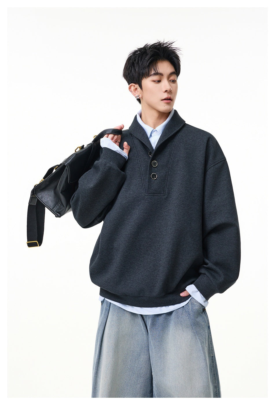 Model wearing a charcoal oversized shawl-collar pullover with a three-button placket over a pale blue shirt.