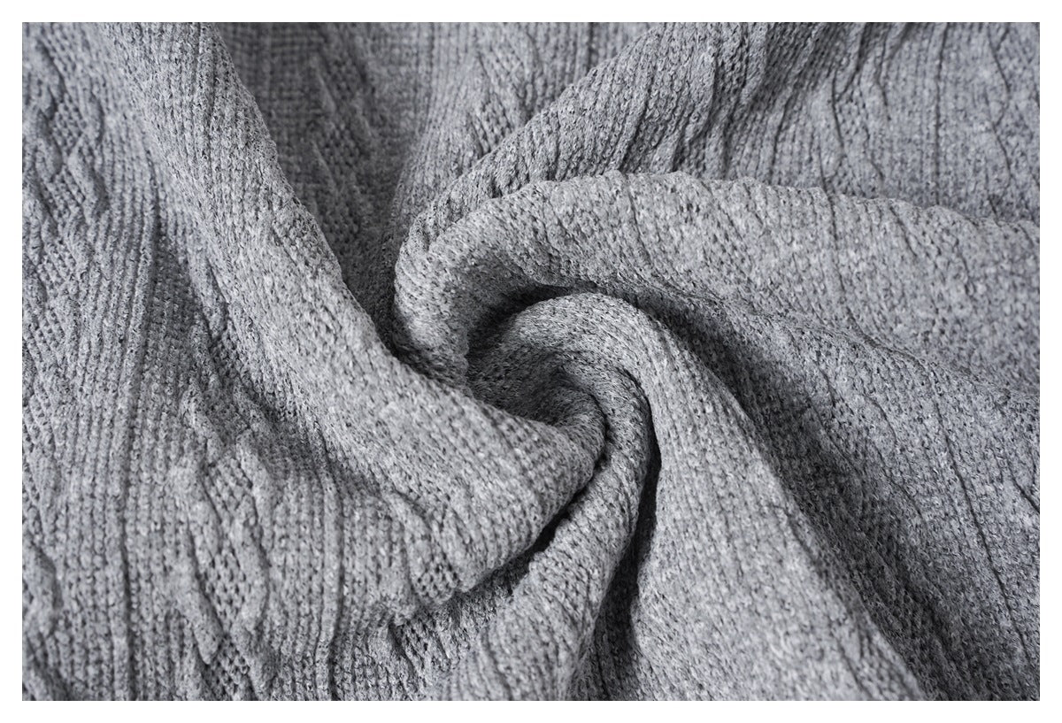 Close-up of gray knit fabric gathered into folds, showing its textured stitch pattern.