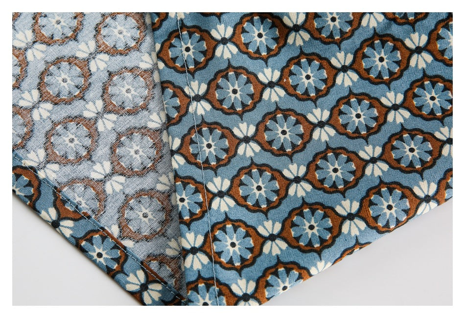 Blue floral fabric shown folded back to reveal its lighter reverse side and seam stitching.