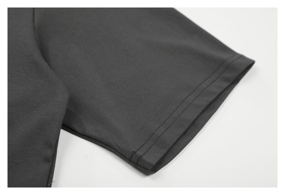 Close-up of a charcoal T-shirt sleeve showing the stitched sleeve hem.