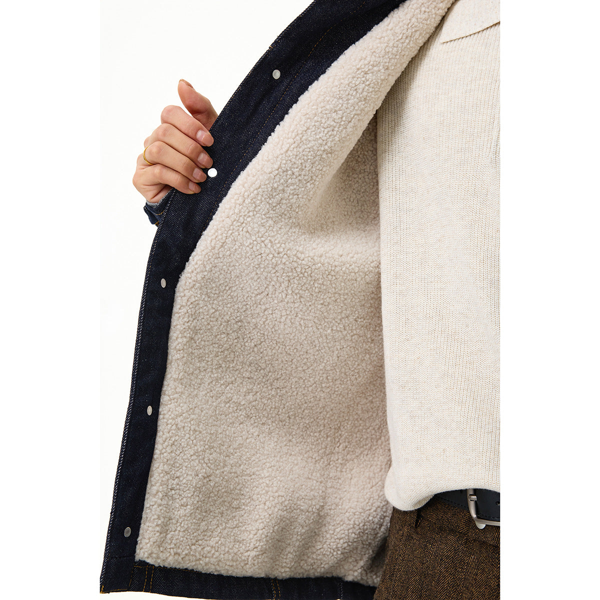 Close-up of the jacket's plush cream lining, dark denim edge, and snap fasteners.