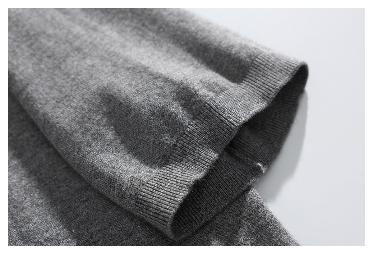 Close-up of a gray sweater sleeve ending in a ribbed cuff.