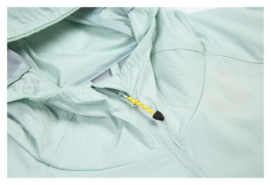 Close-up of a mint jacket’s front zipper with a yellow cord pull and black end piece.