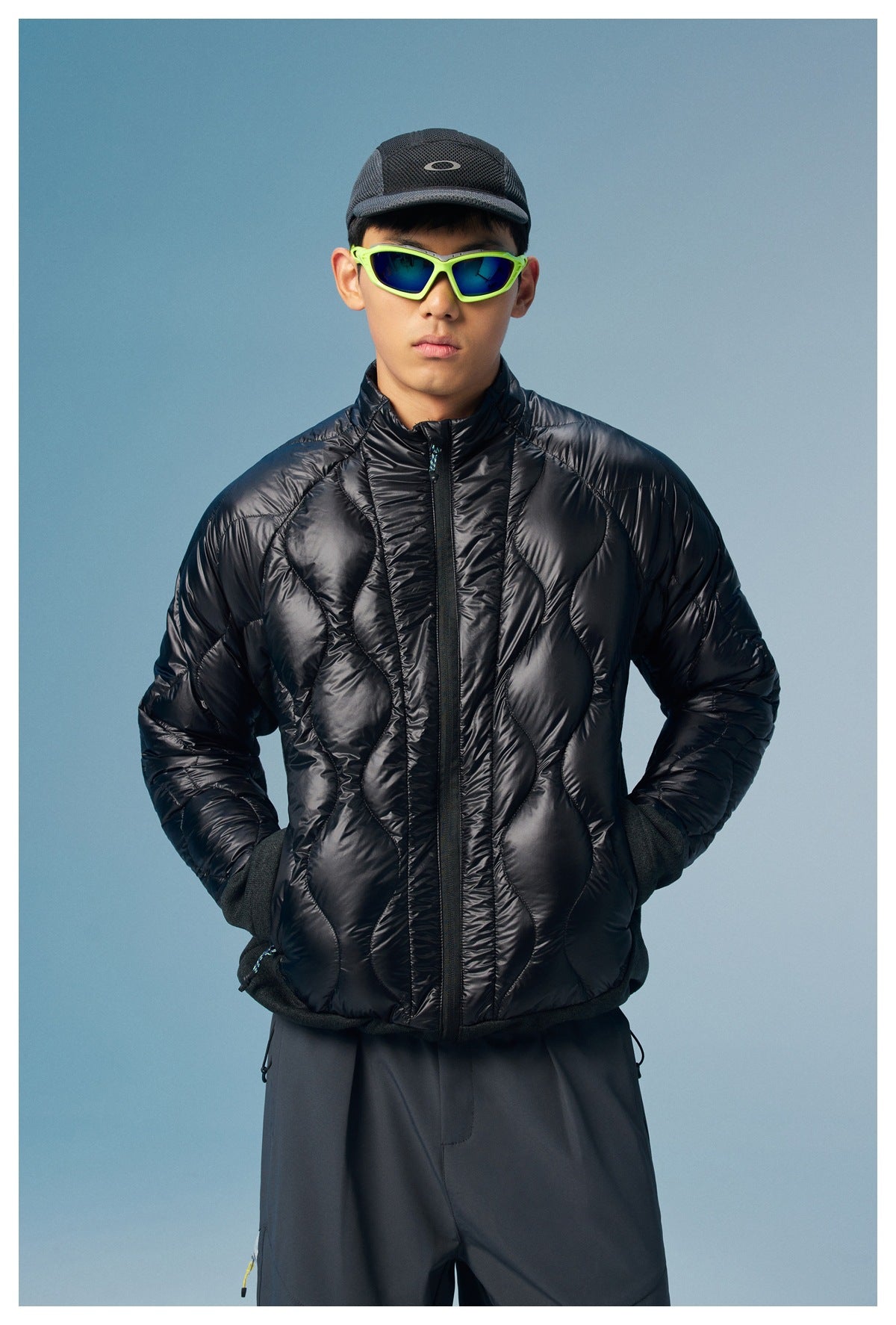 Front view of a man wearing a black diamond-quilted zip jacket with a high collar and dark cuffs.