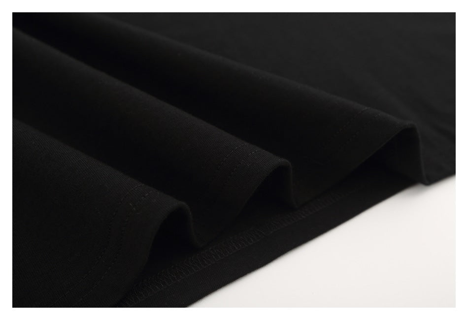 Close-up of the black T-shirt’s folded hem and parallel stitching.