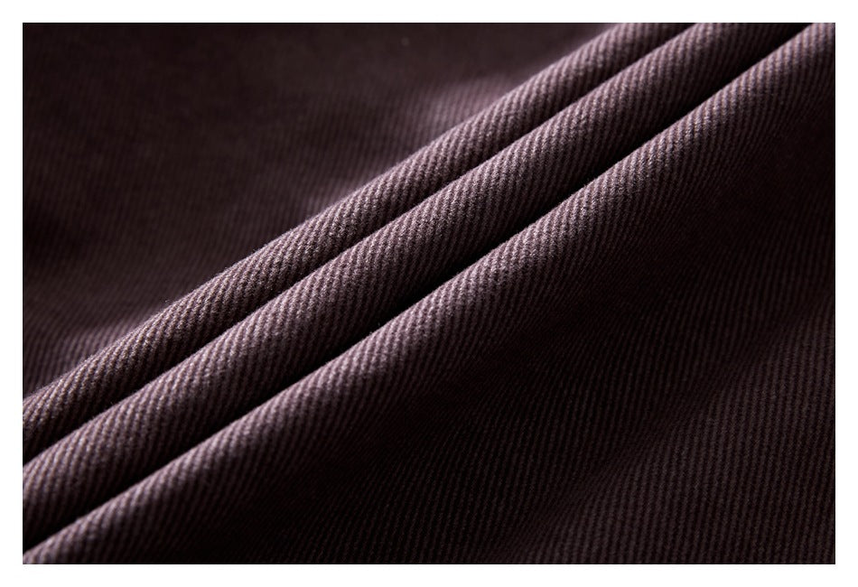 Close-up of dark mauve-brown fabric folded to show its fine diagonal ribbed texture.