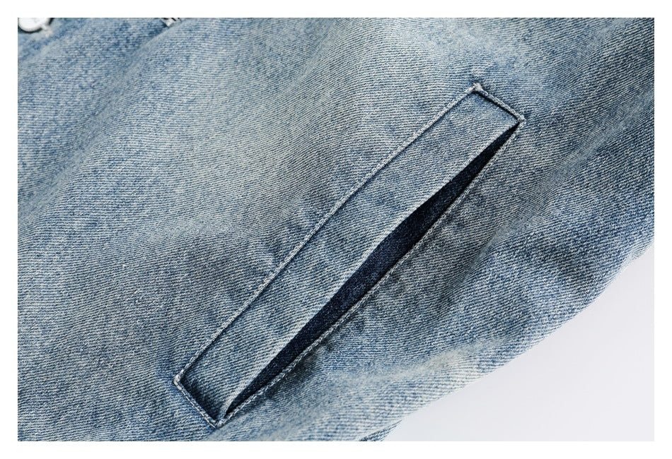 Close-up of a narrow welt pocket on light blue denim.