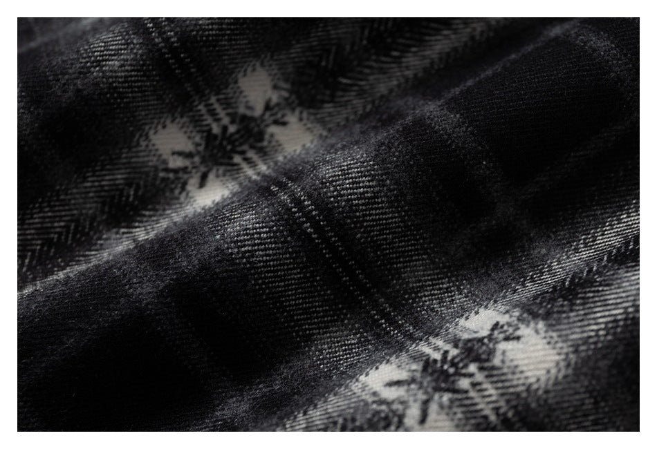 Macro view of the woven black and gray plaid pattern on shirt fabric.
