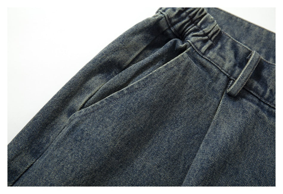 Close-up of a front pocket and belt loop on faded blue jeans.