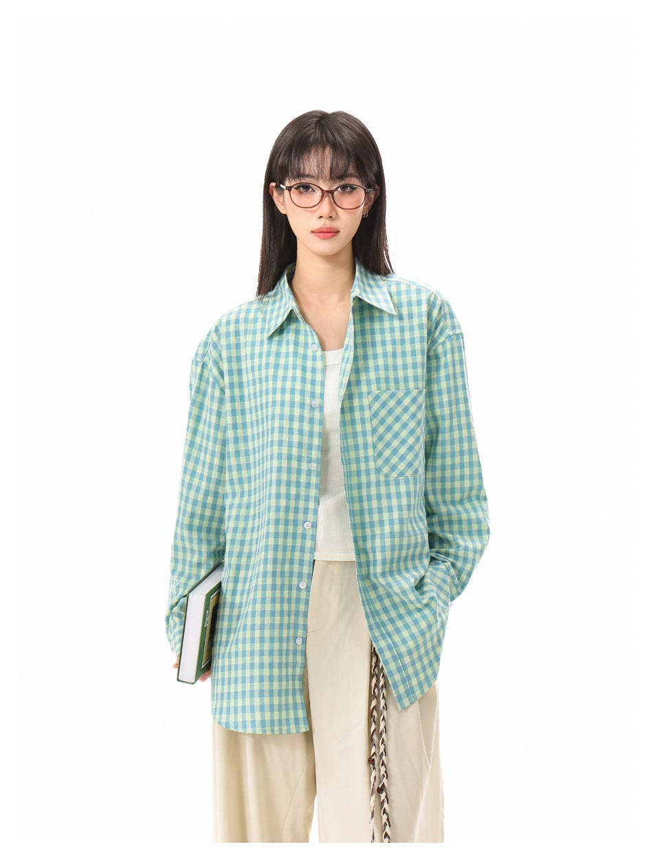 Front view of a model wearing an oversized teal and pale yellow gingham shirt with a chest pocket.