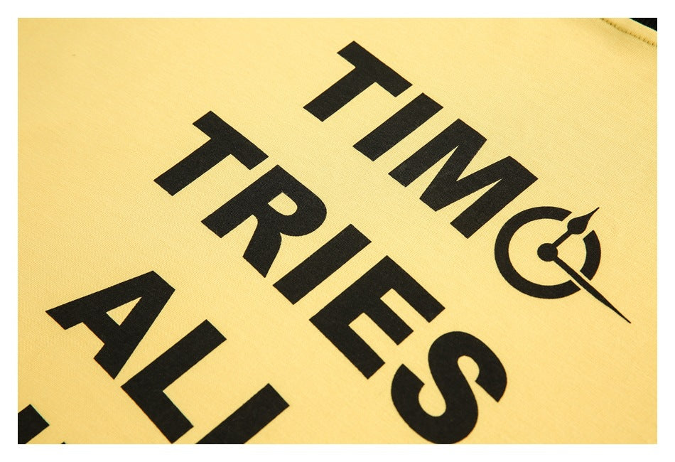 Close-up of black printed lettering and a clock motif on yellow fabric.