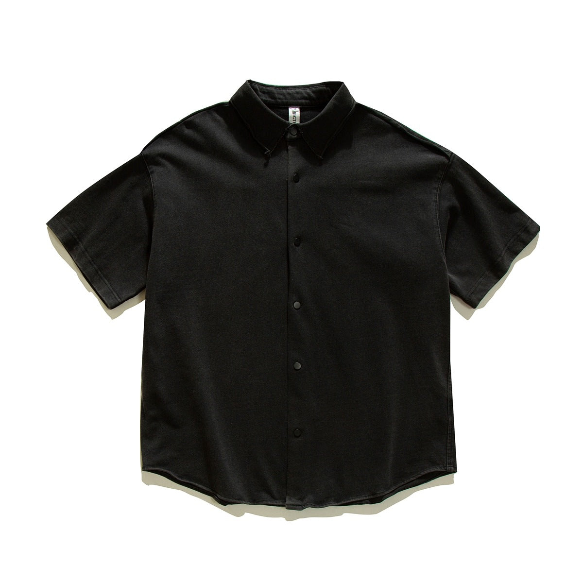 Black short-sleeve shirt flat lay with pointed collar, snap front placket and curved hem