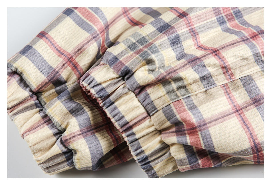Close-up of gathered elastic cuffs on the cream plaid jacket sleeves.
