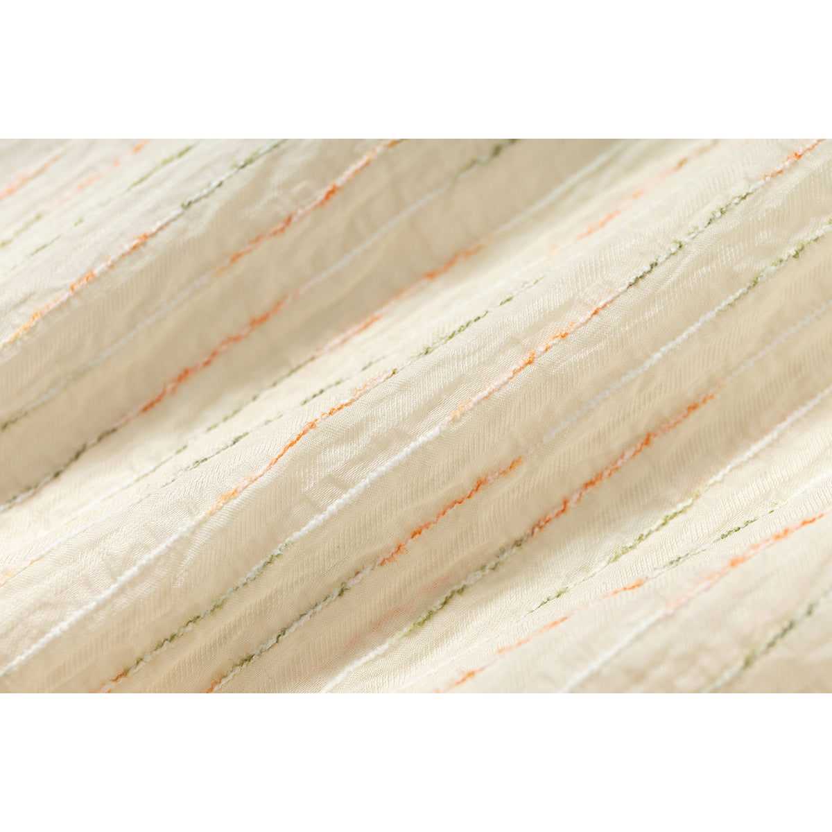 Macro view of ivory shirt fabric with raised, irregular orange, olive, and white lines.