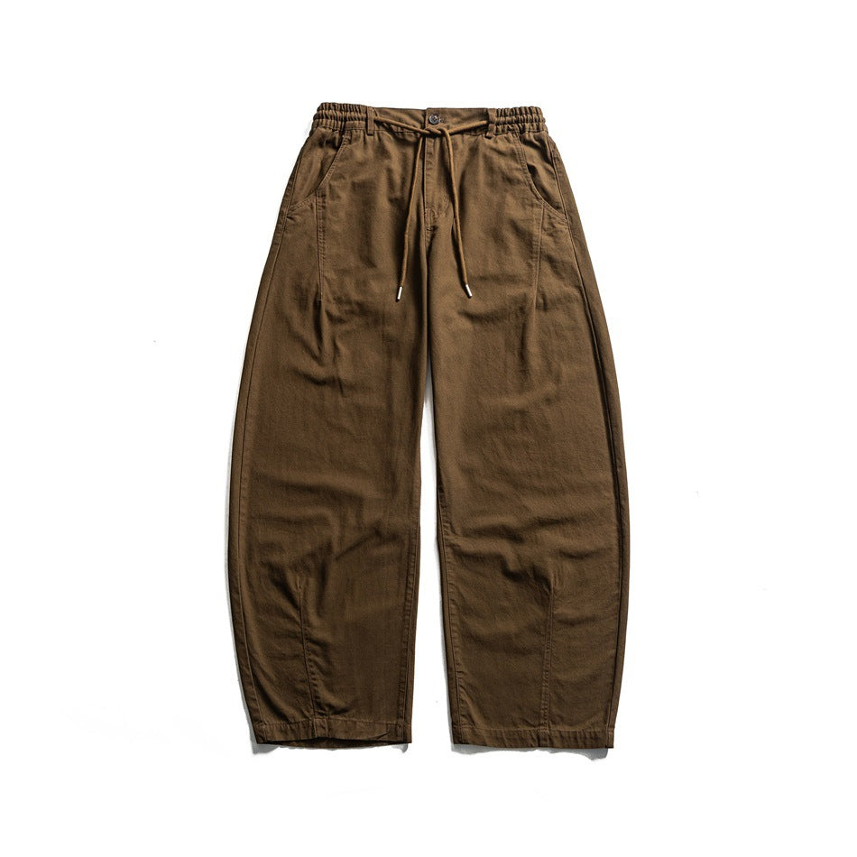Front view of brown wide-leg pants with drawstring, button front, elastic waistband and curved leg seams