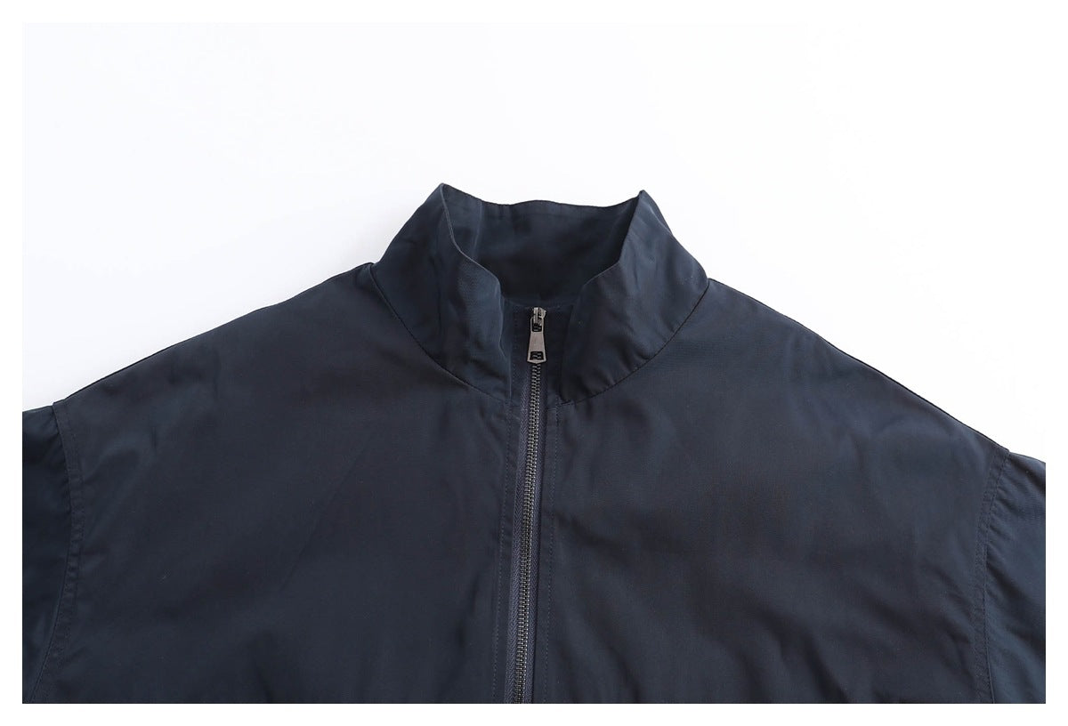 Close-up of a dark navy jacket's stand collar and central zipper.