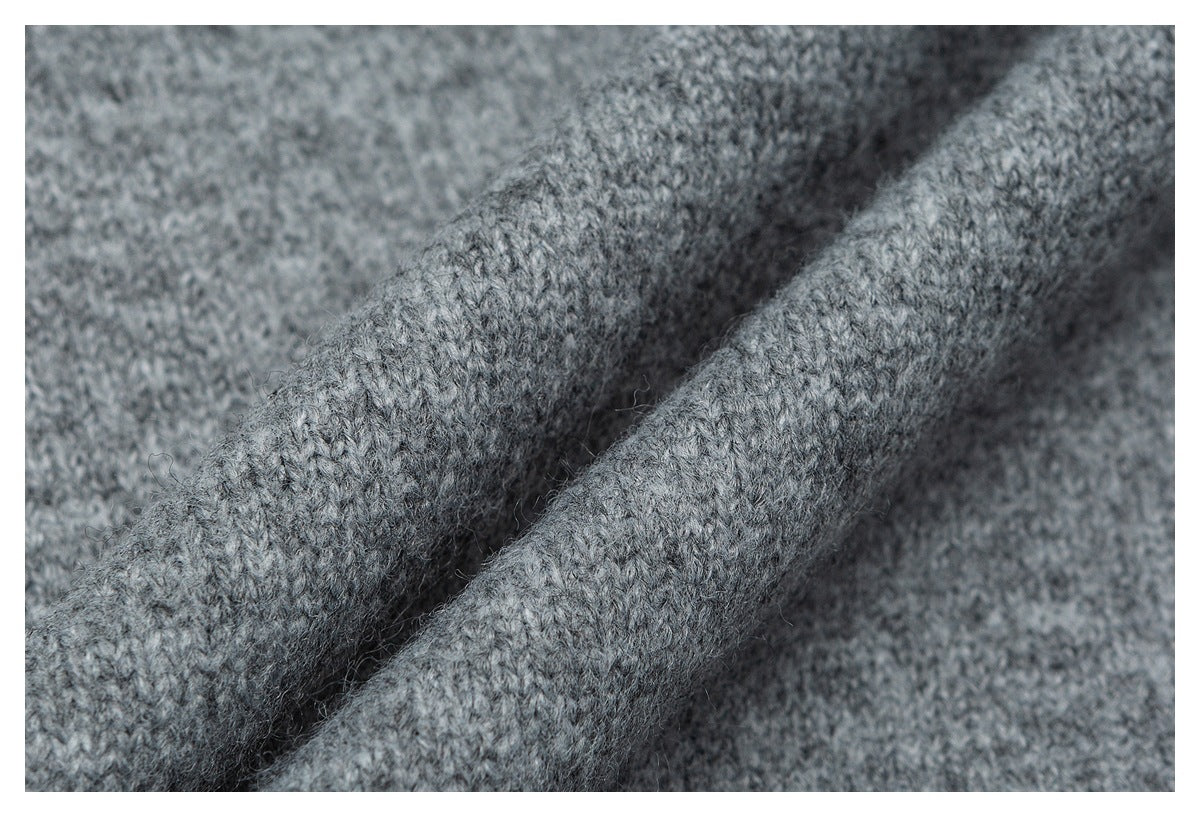 Macro view of the soft, mottled gray knit texture and folded fabric.