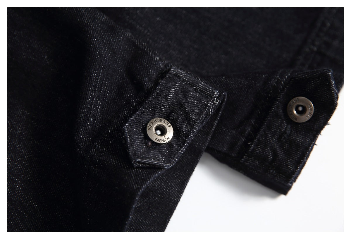 Close-up of two metal snap buttons on a black denim hem tab.