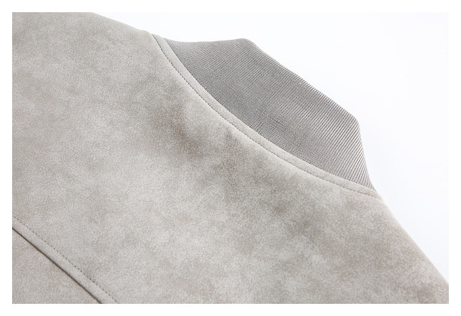Close-up of the light taupe jacket's curved neckline and textured dark inner collar.