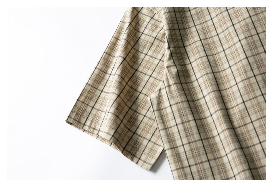 Close-up of a beige plaid shirt sleeve and body on a white background.