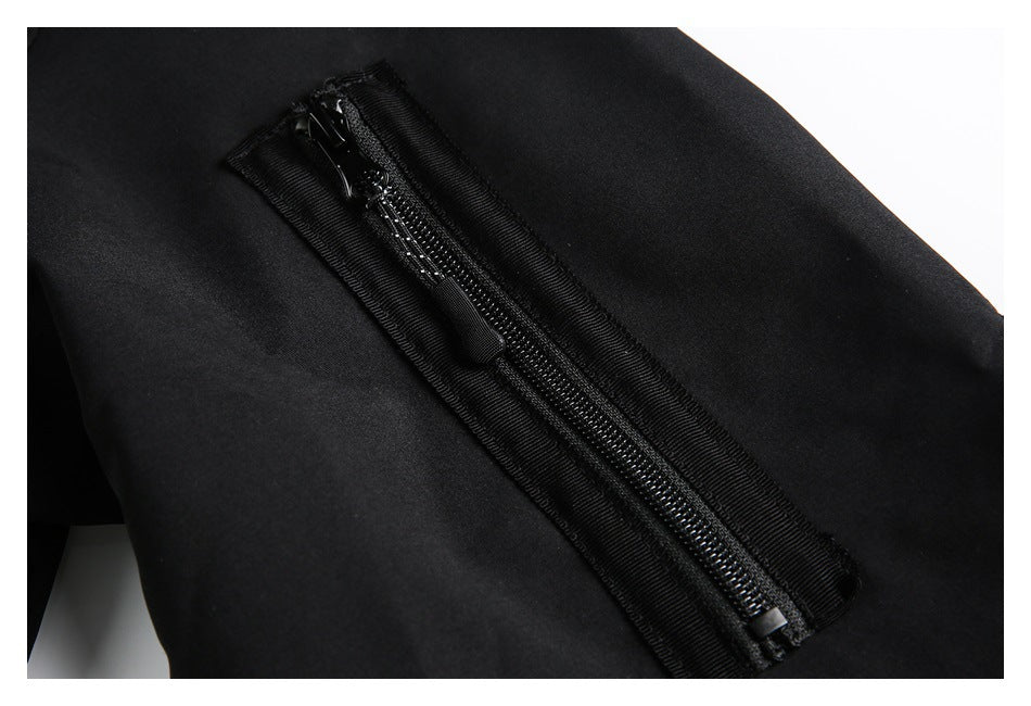 Close-up of a black garment with a long black zipper and pull on smooth fabric.