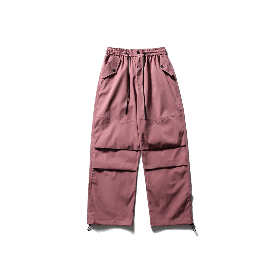 Berry red wide-leg parachute pants flat lay with drawcord waist, flap pockets, knee pleats and hem toggles